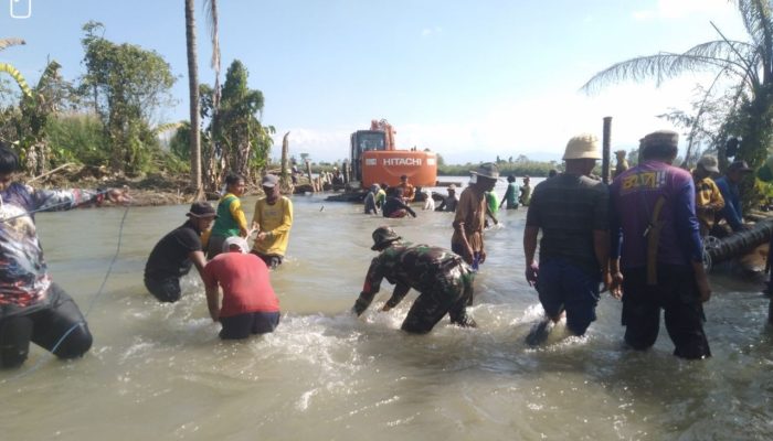 Babinsa Desa Lara Serda Imam Juli.H Bersama Masyarakat Pasang Patok Tanggul yang Jebol